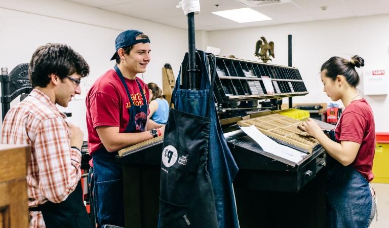 Students work at printer press.